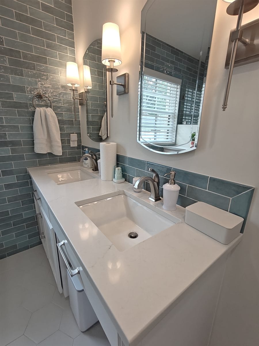 Freshly cleaned double vanity with polished quartz counter, sinks and fixtures